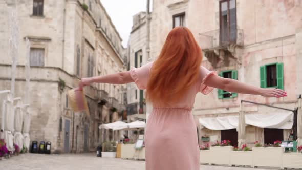 Happy Woman Tourist Laughs and Whirls on Street of Old European City