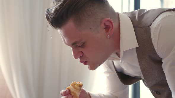 Businessman in Threepiece Suit Vest Hurriedly Eats Pizza While Leaning Over It