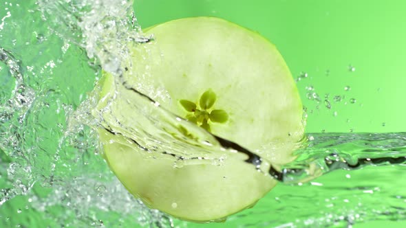 Super Slow Motion Shot of Rotating Fresh Green Apple Slice and Splashing Water at 1000Fps