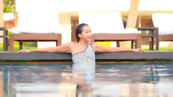 Young asian woman enjoy around outdoor swimming pool for leisure