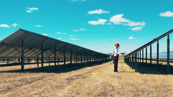 Male Engineer Is Working at the Outdoors Solar Power Field