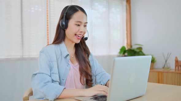 Asian Telemarketing or call center with headset work to support costumer on computer laptop at home.