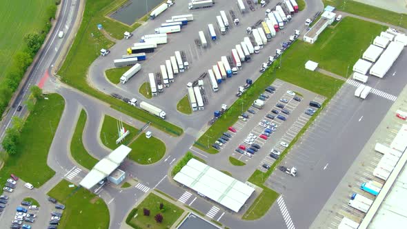 Aerial top down view of the big logistics park with warehouses, loading hub and a lot of semi trucks