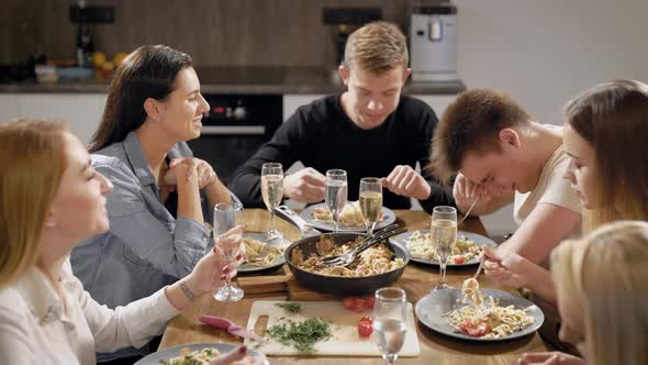 Happy Young People at Table in Kitchen