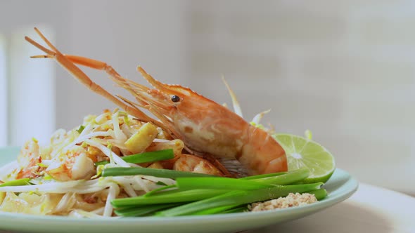 Prawn Pad Thai noodle dish on kitchen table, dolly shot