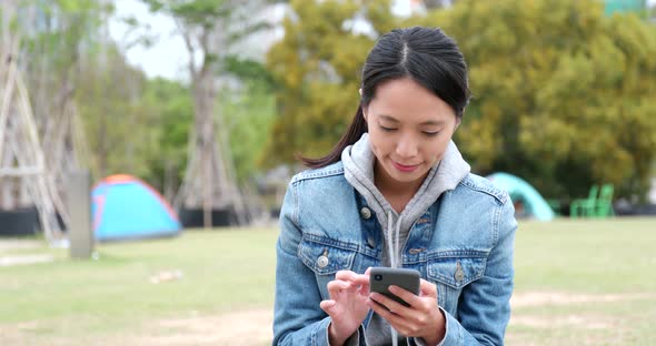 Young woman use of mobile phone at outdoor park