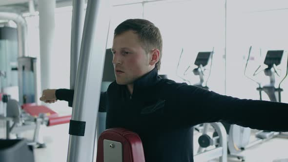 Young man is engaged in crossfit, doing leg exercises, warming up, in the gym.