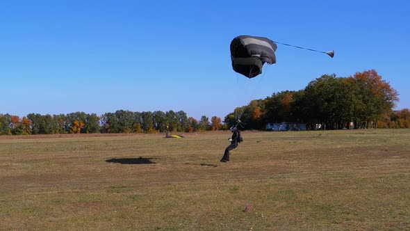 Skydiver Flying with a Parachute and Landed on the Ground. Slow Motion