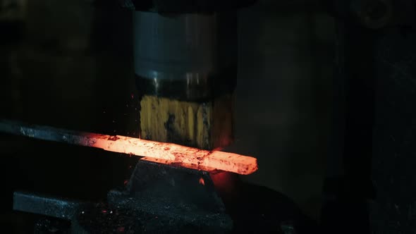 Hydraulic Hammer Shaping Piece of Hot Iron. Blacksmith Forges Red-hot Metal in Workshop