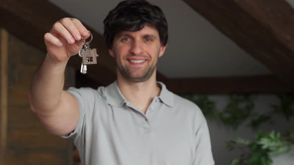 Young Smiling Man Showing Keys to New Home