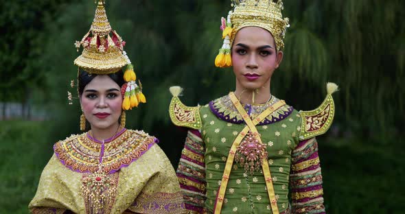 Thai woman and man in traditional dress looking at camera