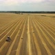 Aerial view: Tractor producing hay bales in a wheat field. Agriculture area - VideoHive Item for Sale