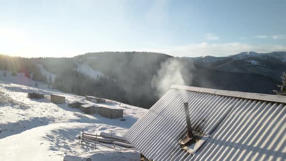 Flying Over Log Cabin Hut With Smoke Coming Out of a Chimney