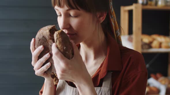 Female Baker Enjoying Smell of Freshly Baked Rye Bread