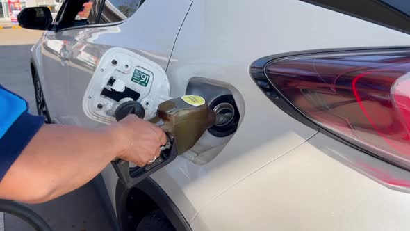 Man pumping gasoline oil to refuleing fuel to a car at petrol station