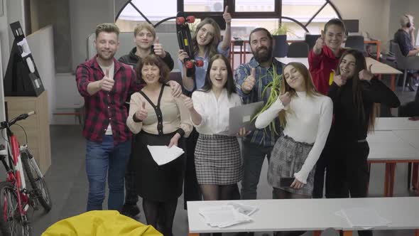 Big Friendly Office Team Smiling and Showing Big Fingers Looking in Camera