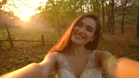 Point of View Shot of Attractive Bride Is Posing Into Camera Against Sunny Rays at Sunset with