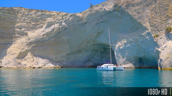 Picturesque Catamaran Anchored off the Rocky Kleftiko Bay Cliffs on Milos Island, Greece