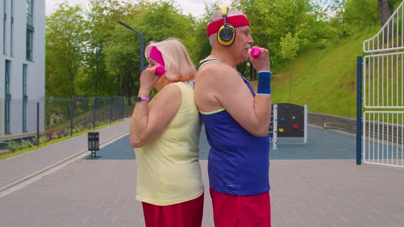 Active Elderly Old Sports Team Grandmother Grandfather Weightlifting Dumbbells Smiling at Camera