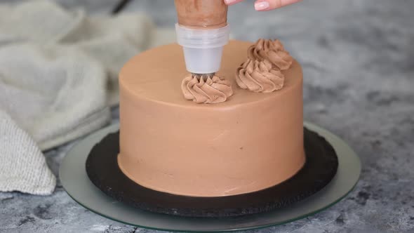 Chef Decorating Chocolate Cake with Cream