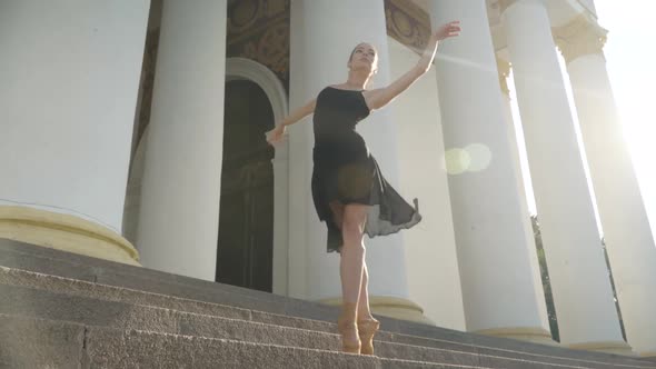 Wide Shot Portrait of Slim Young Woman Dancing on Tiptoes in Sunrays Outdoors