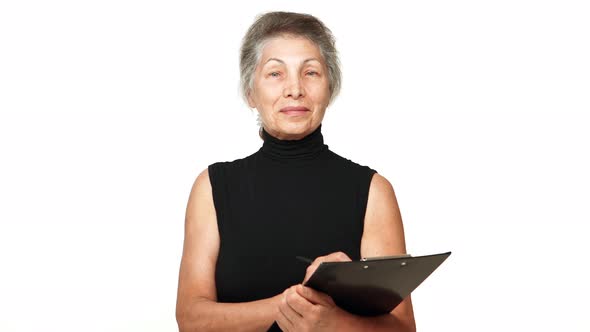 Picture of Elderly Businesswoman with White Temples Holding Clipboard Looking at Camera Nodding with