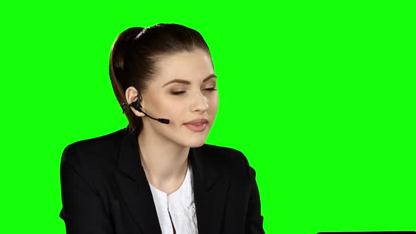 Female Receptionist Working on Computer and Talking on the Telephone in Call Center, Green Screen