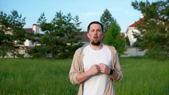 An Adult Male Who Sports Actively Runs Through the Park in the Summer