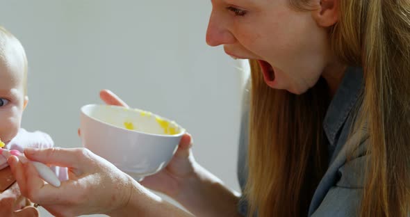 Parents feeding their baby boy at home 