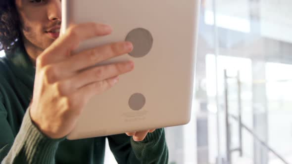 Man using digital tablet in cafe