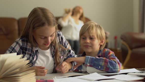 Adorable Little Brother and Sister Studying at Home