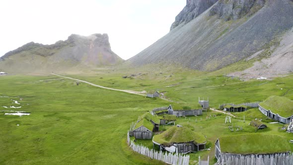 Greenery Landscape With Traditional Wooden Houses In Viking Village At Vestrahorn Mountain, Iceland.