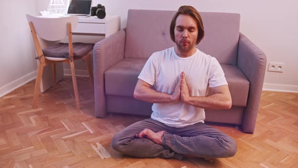 Young Bearded Man Meditating in His Appartment