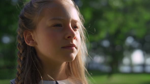 Thoughtful Pretty Girl Looking in Distance in City Park Closeup