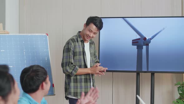 Asian Man Engineer With Solar Cell Succeed Presenting About The Wind Turbine At The Office