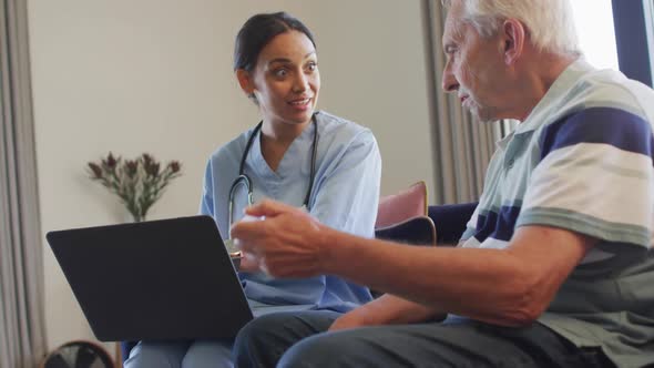 Animation of happy caucasian senior man talking with biracial female doctor using laptop