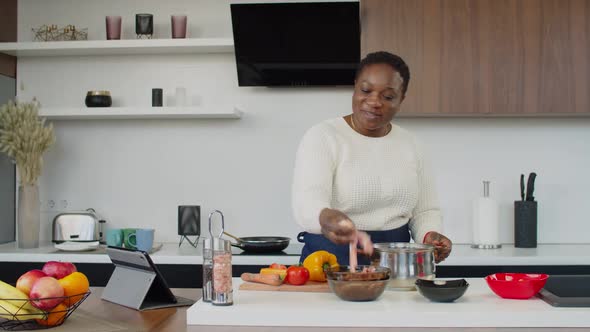 Black Housewife Having Video Call on Tablet Pc During Cooking