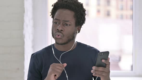 Portrait of Young African American Man Listening Music with Head Phones