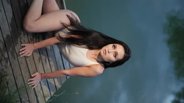 Woman in a Bodysuit Posing on a Wooden Pier By the Lake