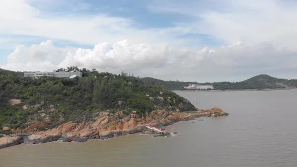 Rotating and ascending aerial view of Coloane coastline, Macau