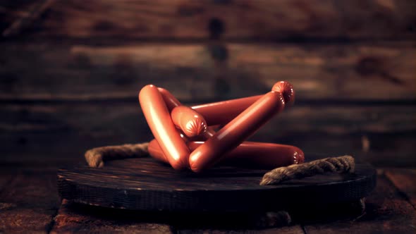 Super Slow Motion Bunch of Sausages Falls on a Wooden Tray