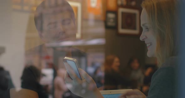 Woman and Man Have a Discussion in the Restaurant Using Smartpho