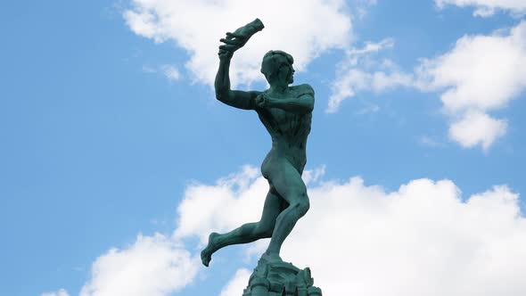 Bronze Statue Of Brabo Monument Against Blue Sky With Clouds In Antwerp, Belgium. Timelapse