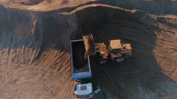 Top View of Excavator with Dump Truck at Quarry