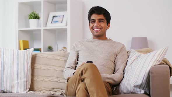 Indian Man with Remote Control Watching Tv at Home 