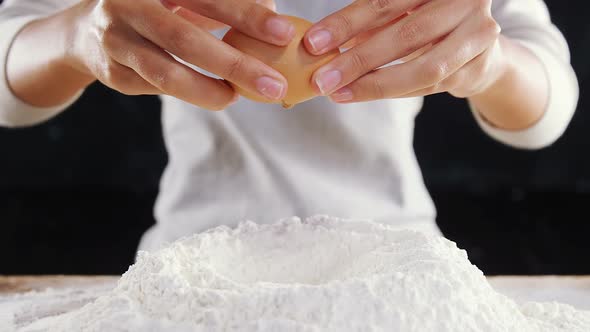 Woman adding egg white into flour