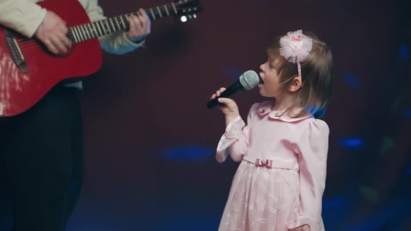 Llittle Girl in Vintage Dress Sings on Stage Her Father Plays Acoustic Guitar