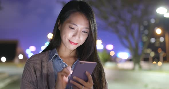 Young Woman Using Mobile Phone at Night