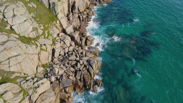 Minack rocky coast in Cornwall. Aerial forward tilt-up reveal