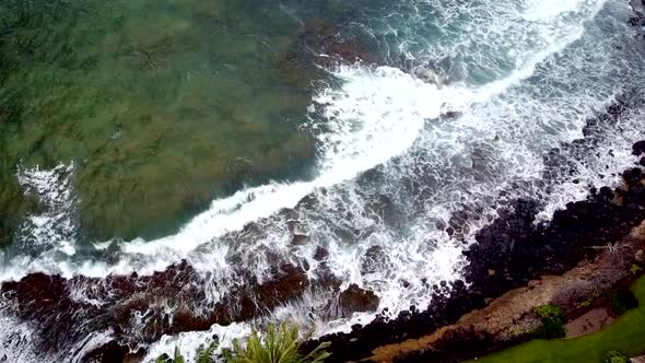 Drone shot. looking directly down and waves hitting shore. 1080p 24fps.